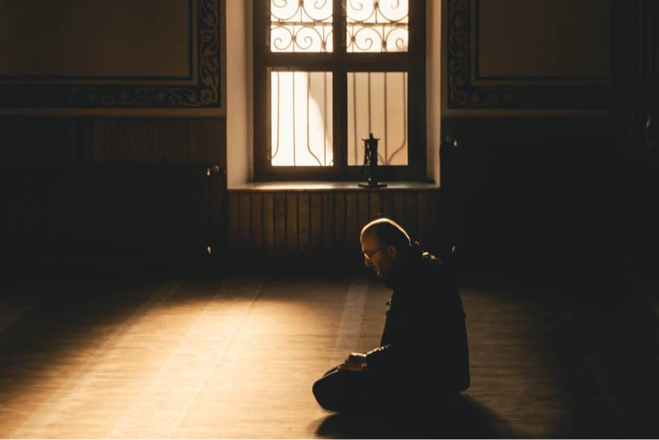 man on knees praying 