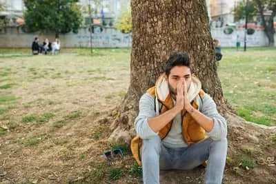 Man behind tree praying