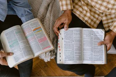 two people sitting with open Bibles