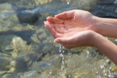 hands picking up water from river