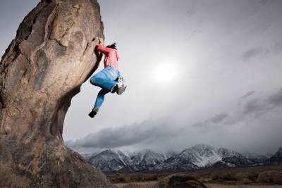 person climbing boulder