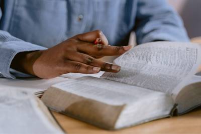 man in blue shirt studying the bible