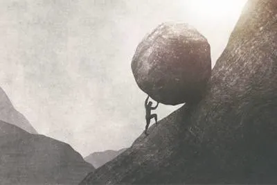 Person pushing a huge boulder up a hill