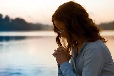women praying near lake