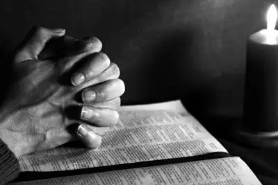 hands folded resting on open bible